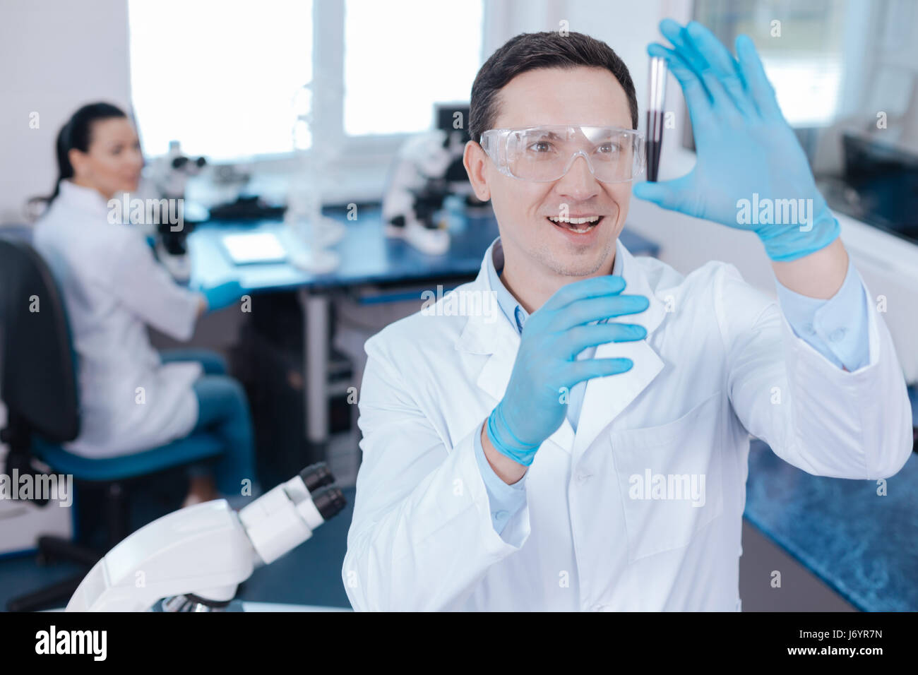 Positive Researcher Positive young researcher looking at reagent Stock Photo - Alamy