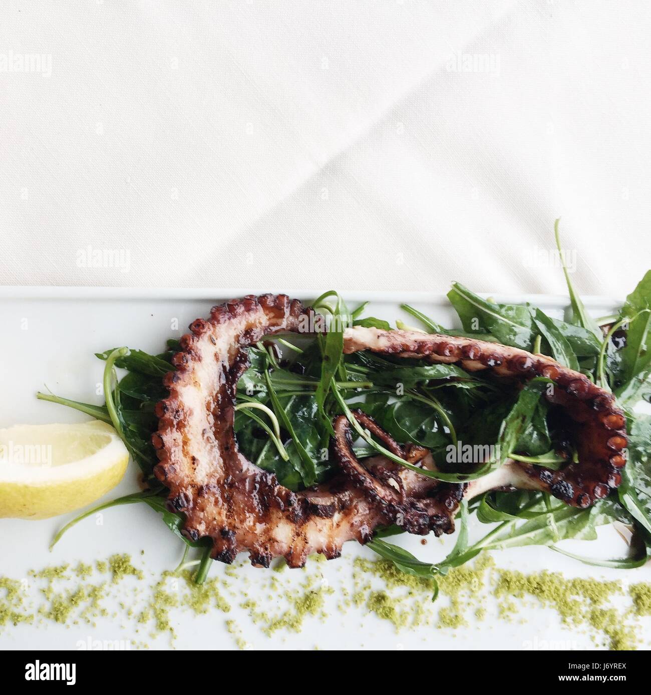 Grilled octopus with lemon and rocket Stock Photo