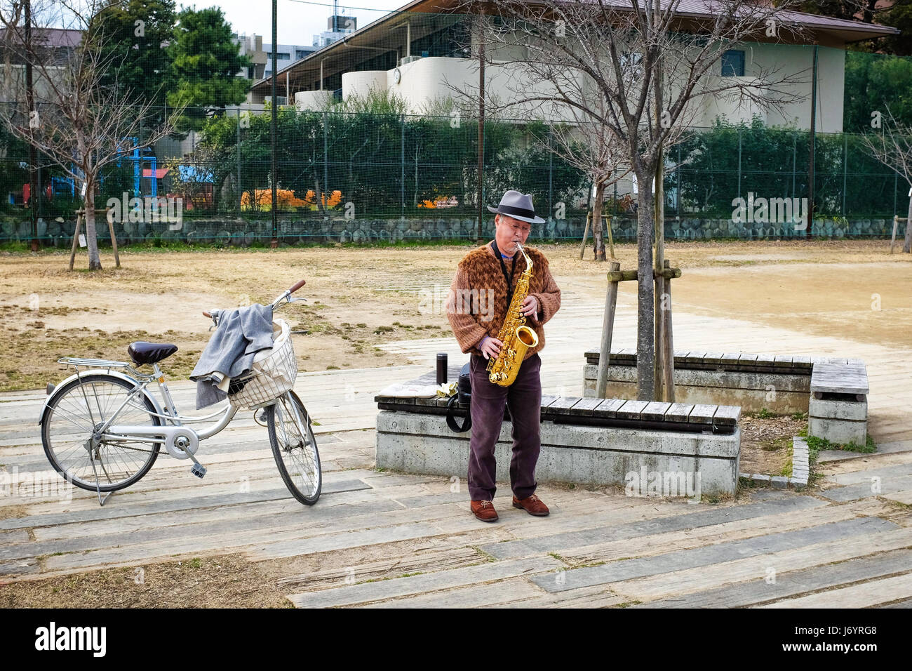 A man practising her saxophone in Kyoto, Japan. Stock Photo
