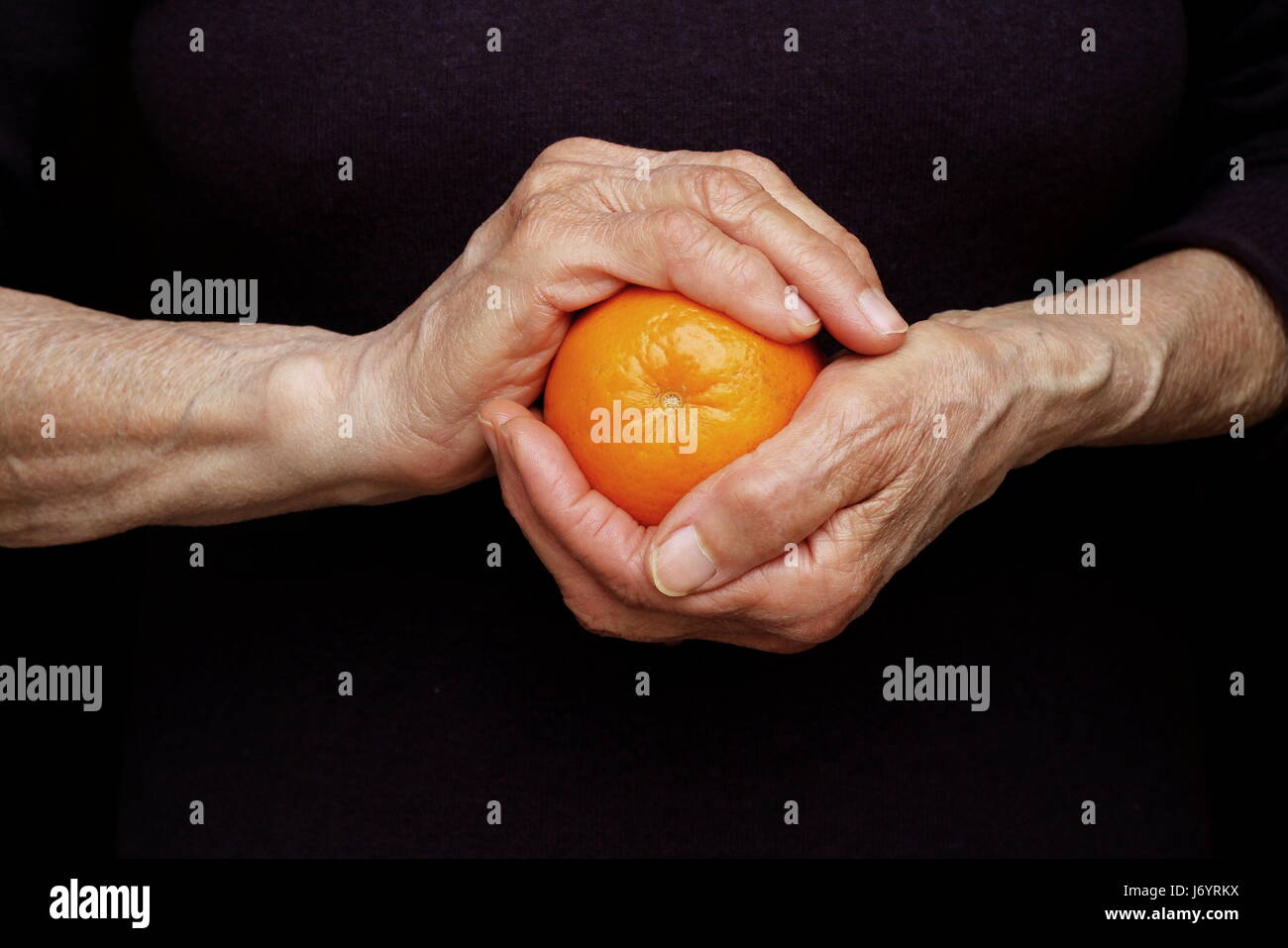 Woman's hands holding an orange Stock Photo - Alamy
