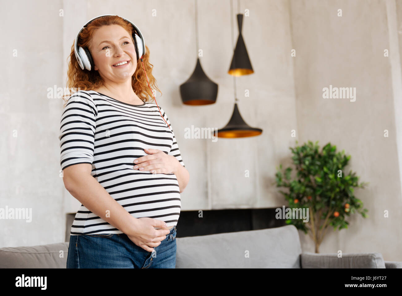 Excited pregnant woman listening to music Stock Photo - Alamy