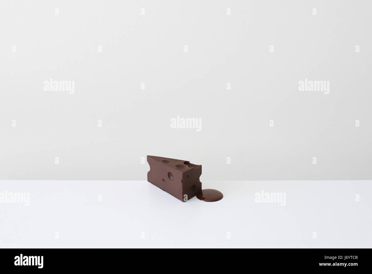 Conceptual slice of cheese shape chocolate melting Stock Photo