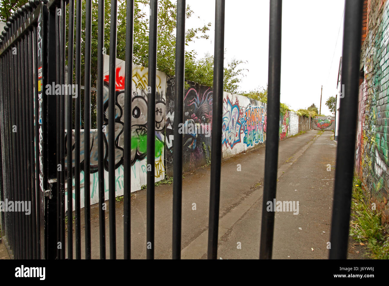 back alley street art behind railings. Stock Photo