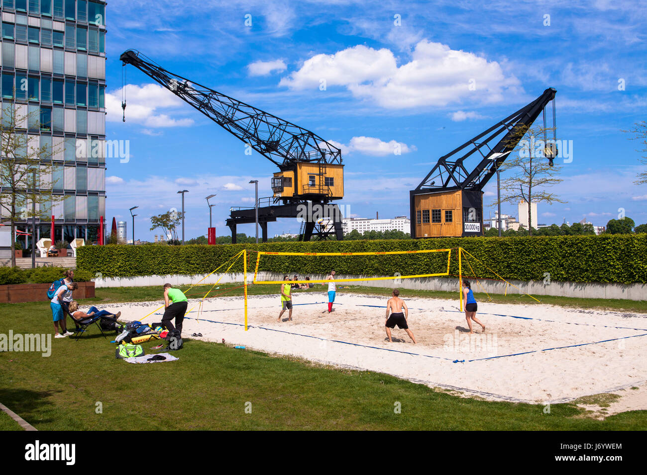 Germany, Cologne, old harbor cranes at the Suedkai in the Rheinau Harbour, beach volleyball field. Stock Photo