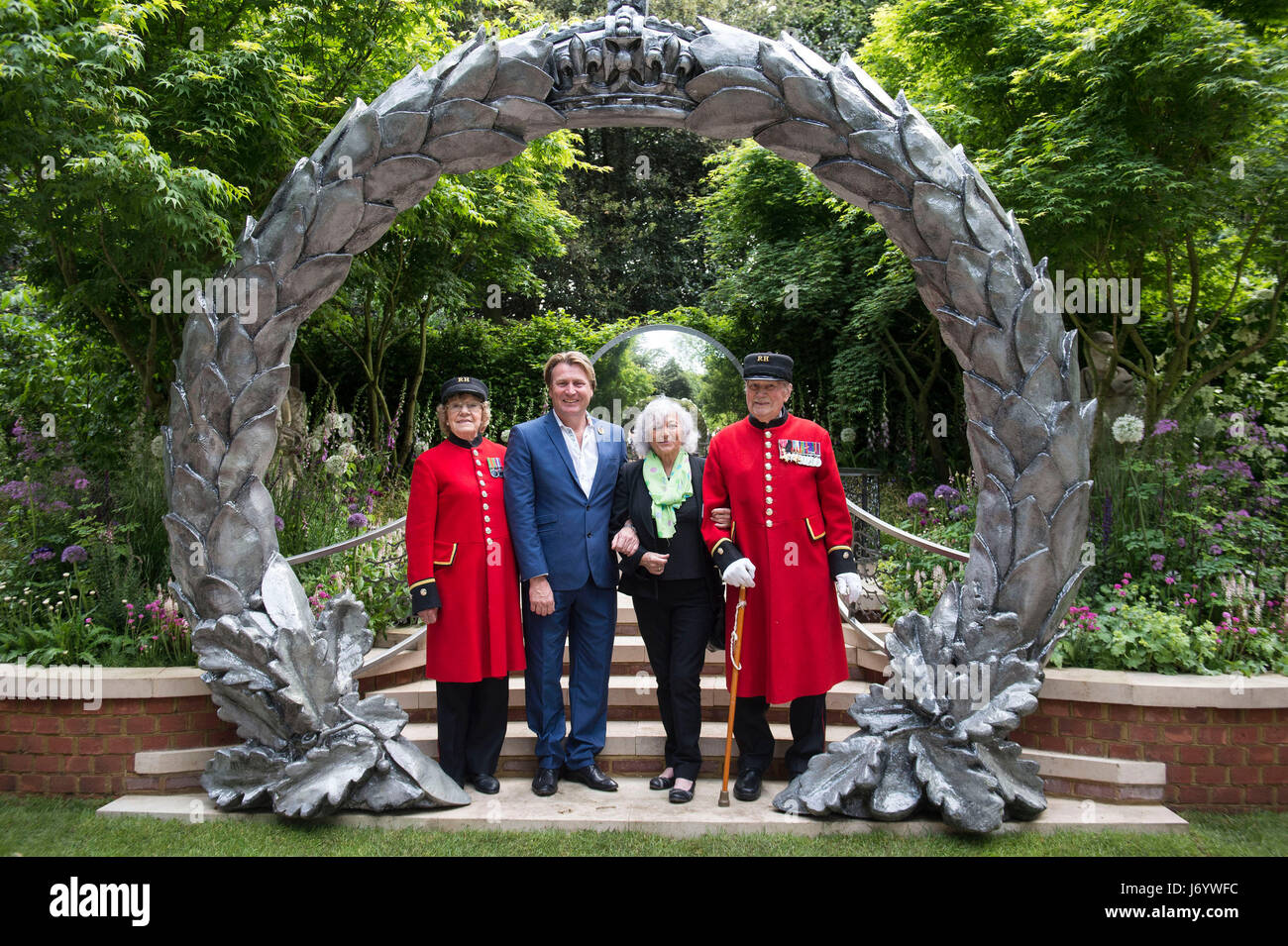 Chelsea Pensioners join garden designer David Domoney and Tania Szabo, daughter of WWII SOE Agent Violette Szabo, at the Commonwealth War Graves Commission (CWGC) Centenary Garden during the press preview of the RHS Chelsea Flower Show at the Royal Hospital Chelsea, London. Stock Photo