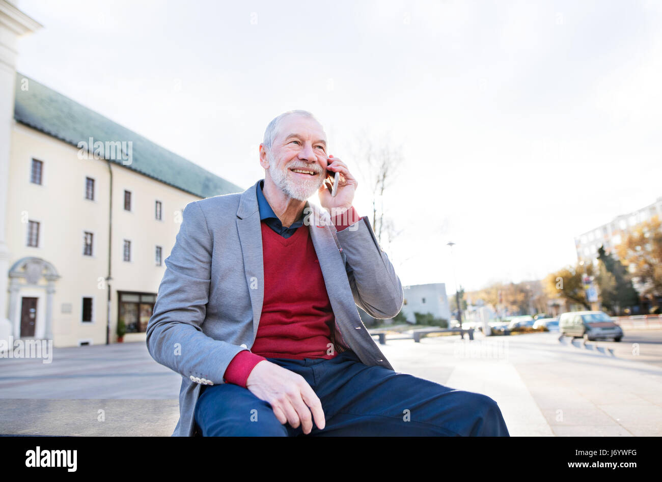 Senior man in town with smart phone, making phone call Stock Photo