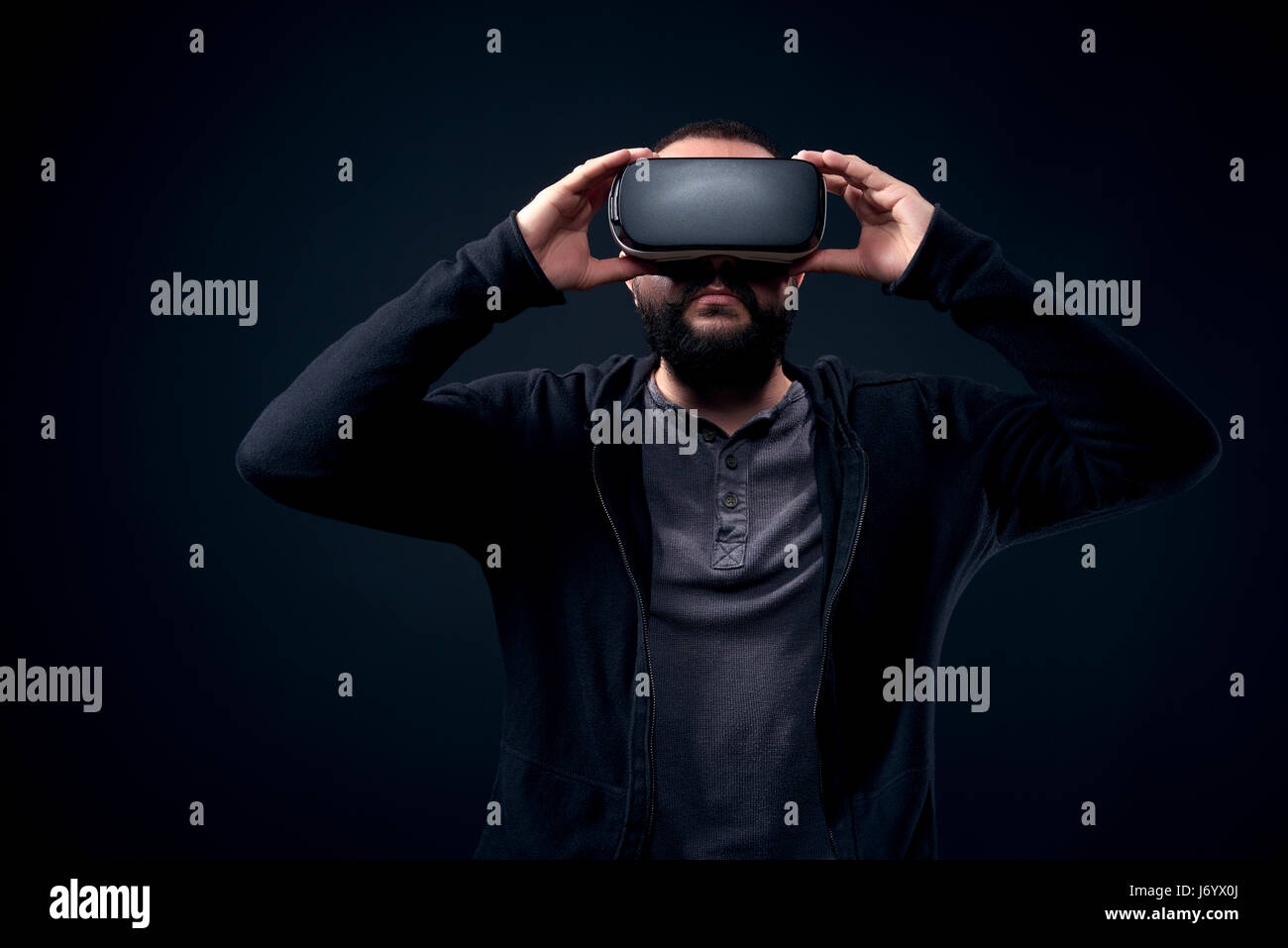 Young hipster bearded man wearing virtual reality goggles. Black