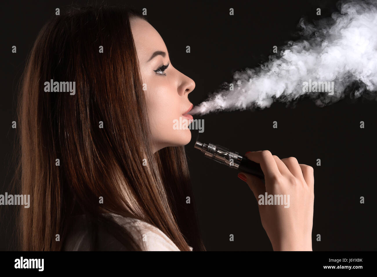 The face of vaping young woman at black studio Stock Photo Alamy