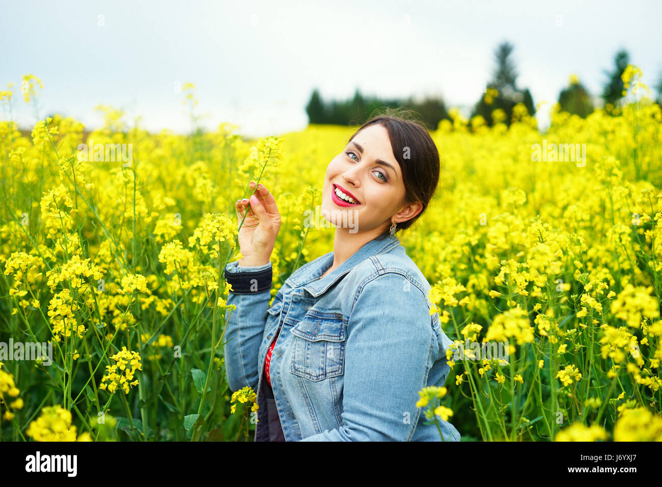 A young caucasian woman in rapeseed field Stock Photo - Alamy