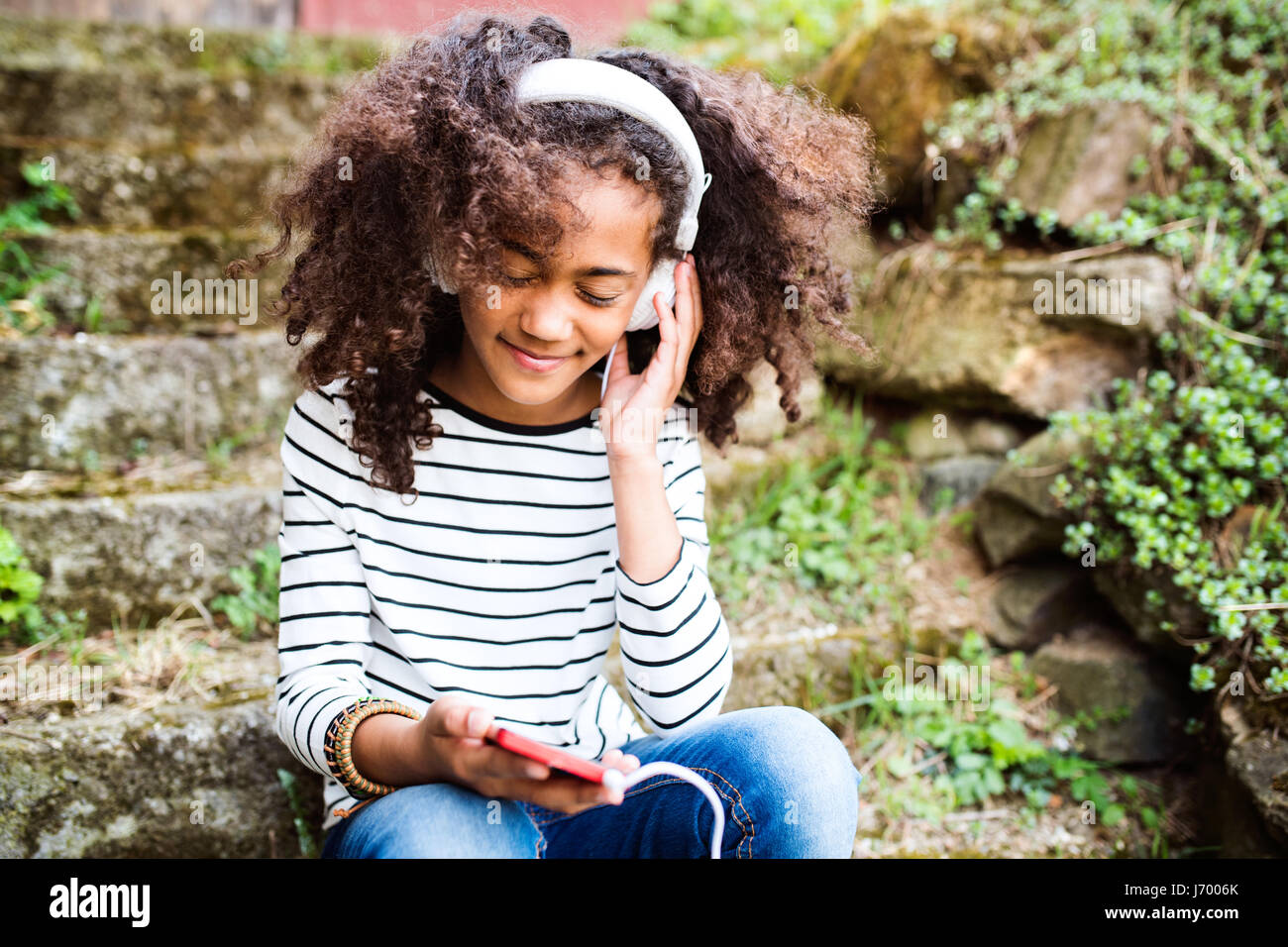 Beautiful african american girl with smart phone and earphones Stock ...