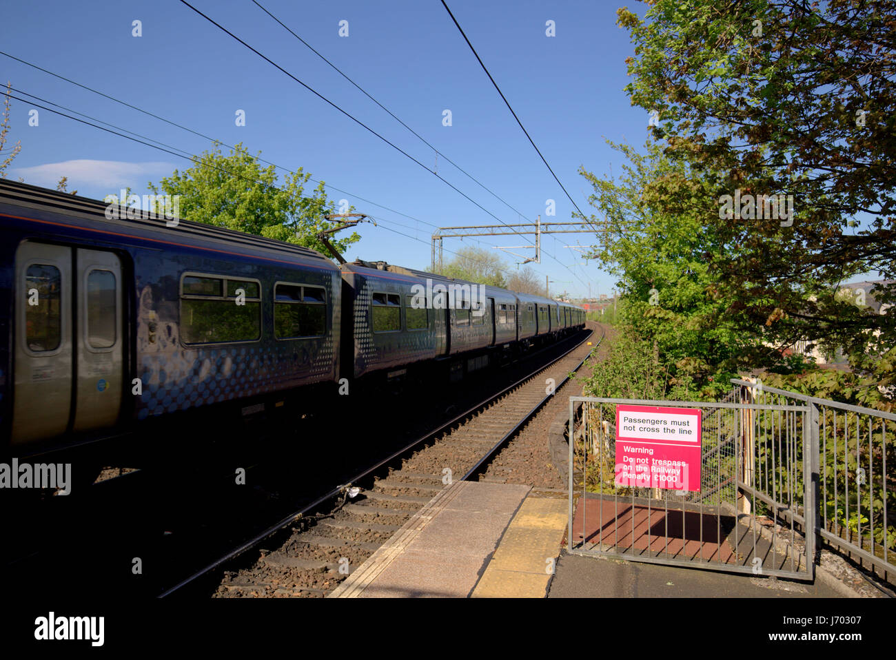 Scotrail train in station no trespassing on the railway sign Drumchapel Stock Photo