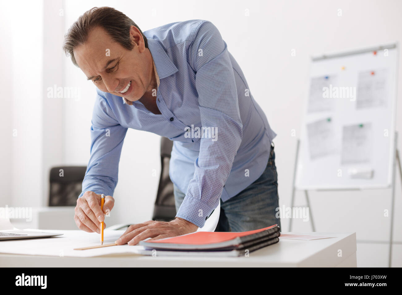 Cheerful engineer drawing a blueprint Stock Photo - Alamy