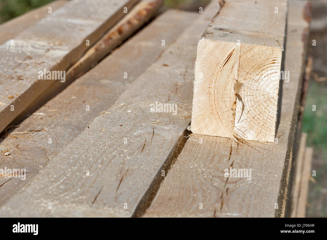 Pile of rectangular and quadratic wooden beams in the construction site, closeup. Stock Photo