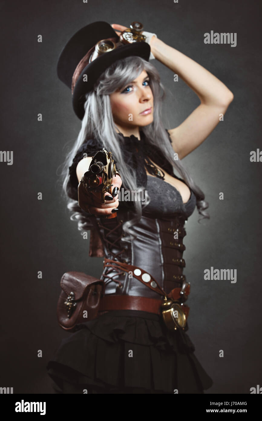 Steampunk woman aiming with gun. Focus on weapon Stock Photo