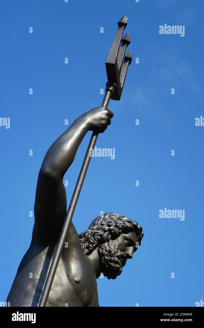 neptune statue with trident in front of sky Stock Photo