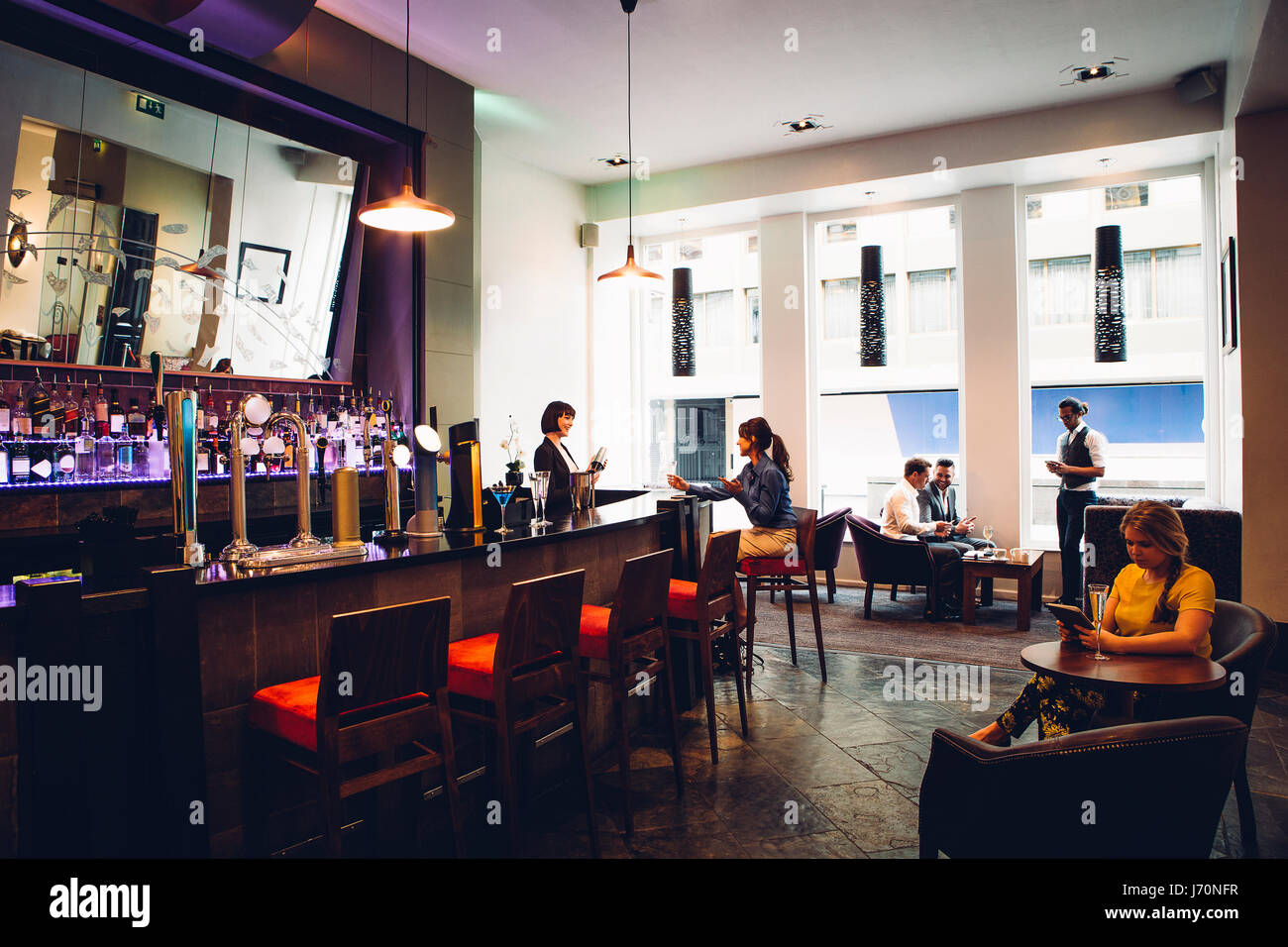Full room shot of an active bar. There are people socialising as well ...