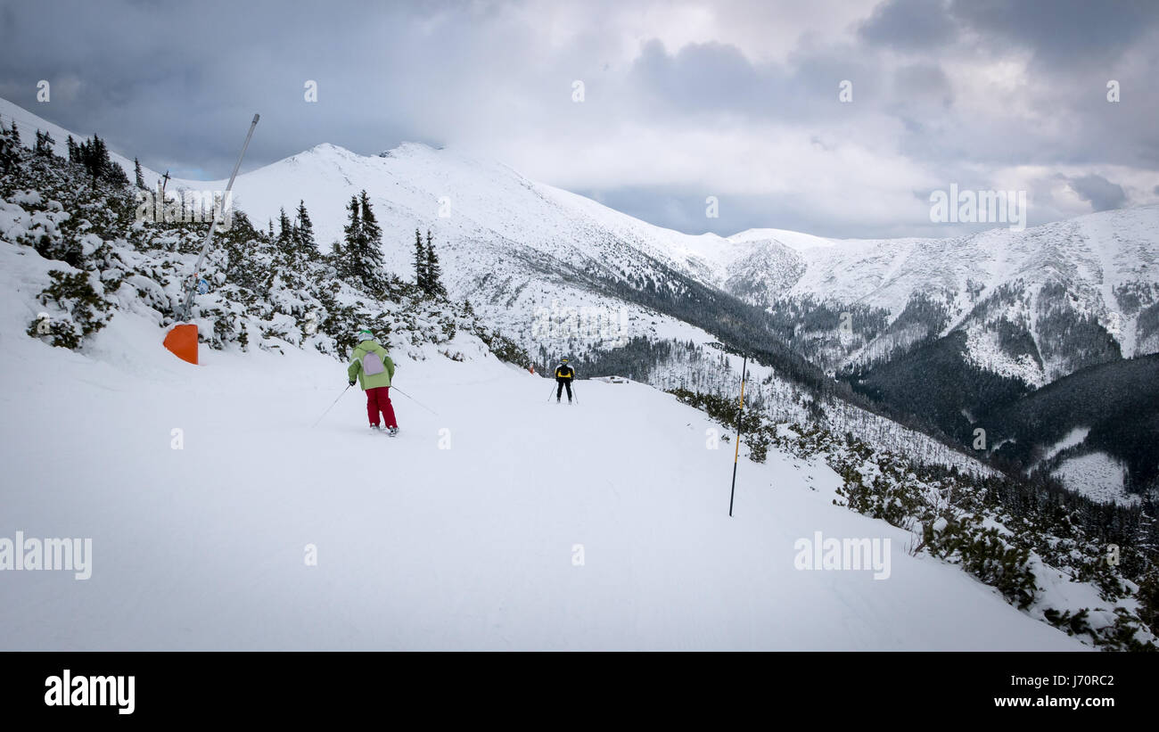 Skiers and snowboarders riding on a ski slope in Jasna Chopok in Slovakia ski resort. Stock Photo