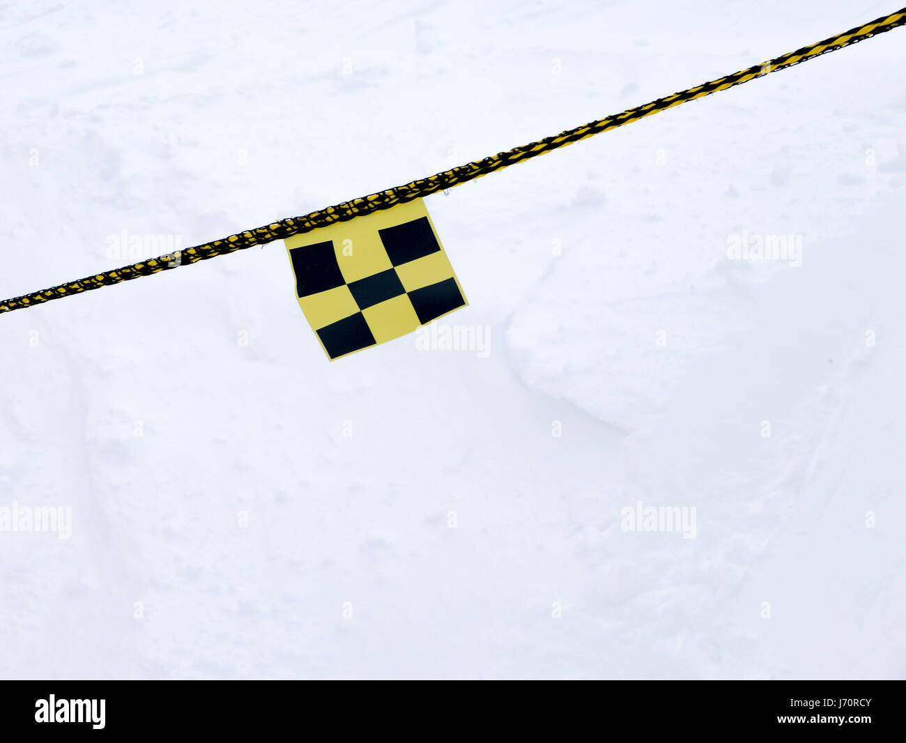 Avalanche danger flag on rope intending to barr the way for safety ...