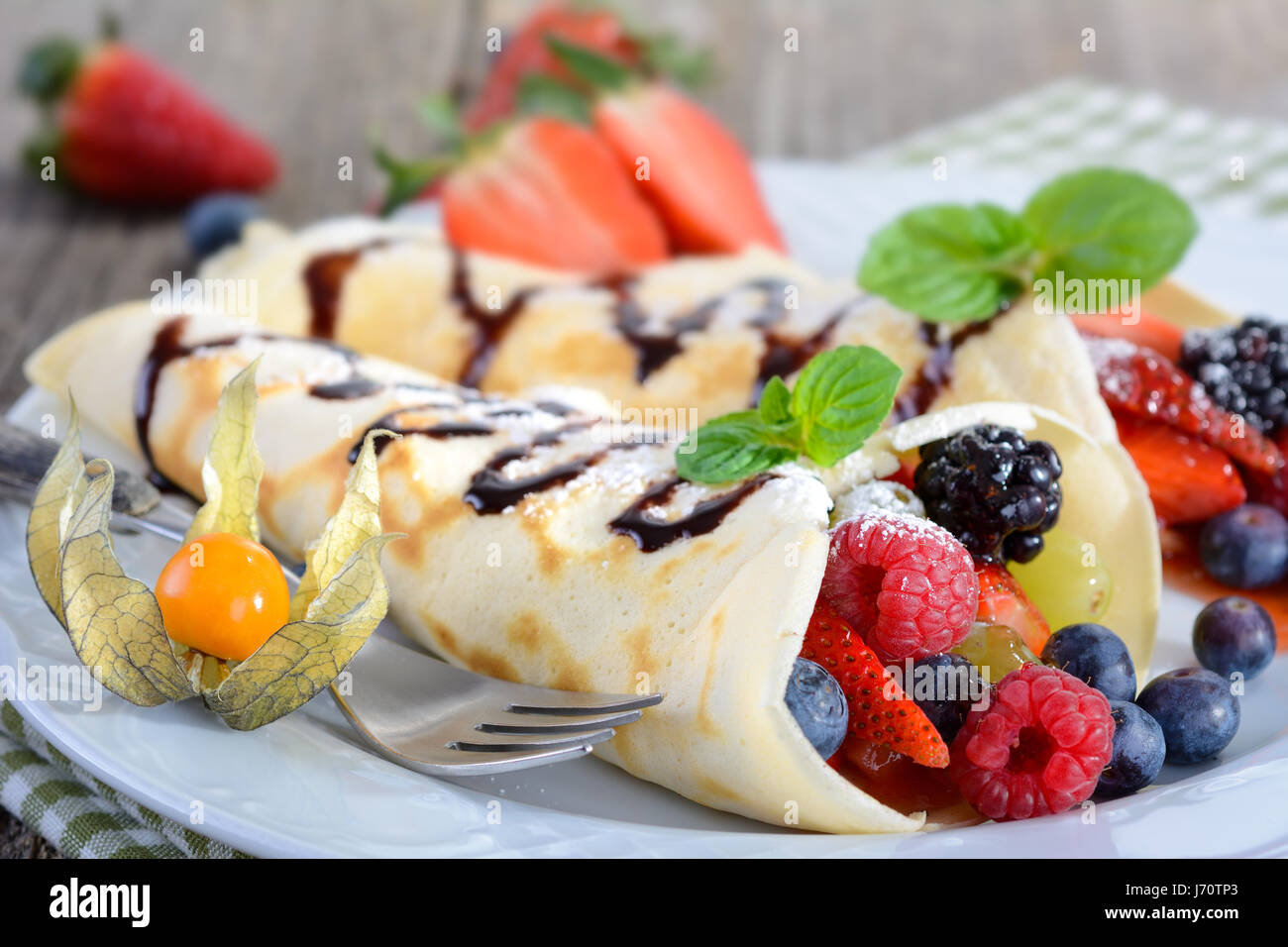 Two homemade pancakes stuffed with mixed fresh berries Stock Photo