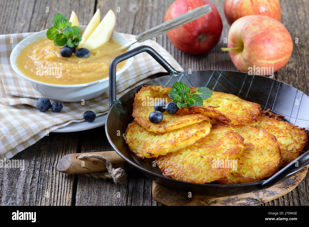 Frying latkes in a skillet, puffs of flour and oil cobwebbing out onto the  stovetop. The cook flipping the potato pancakes with a spatula, kids  eagerly peeking inside the skillet. Generative AI