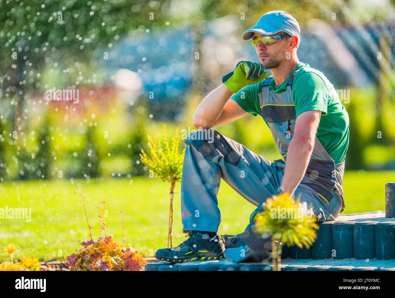 Professional Caucasian Garden Designer in His 30s Taking Break To Rethink New Landscaping Ideas. Gardening Concept. Stock Photo