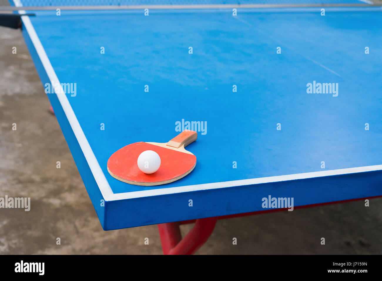 pingpong racket and ball on a blue pingpong table Stock Photo