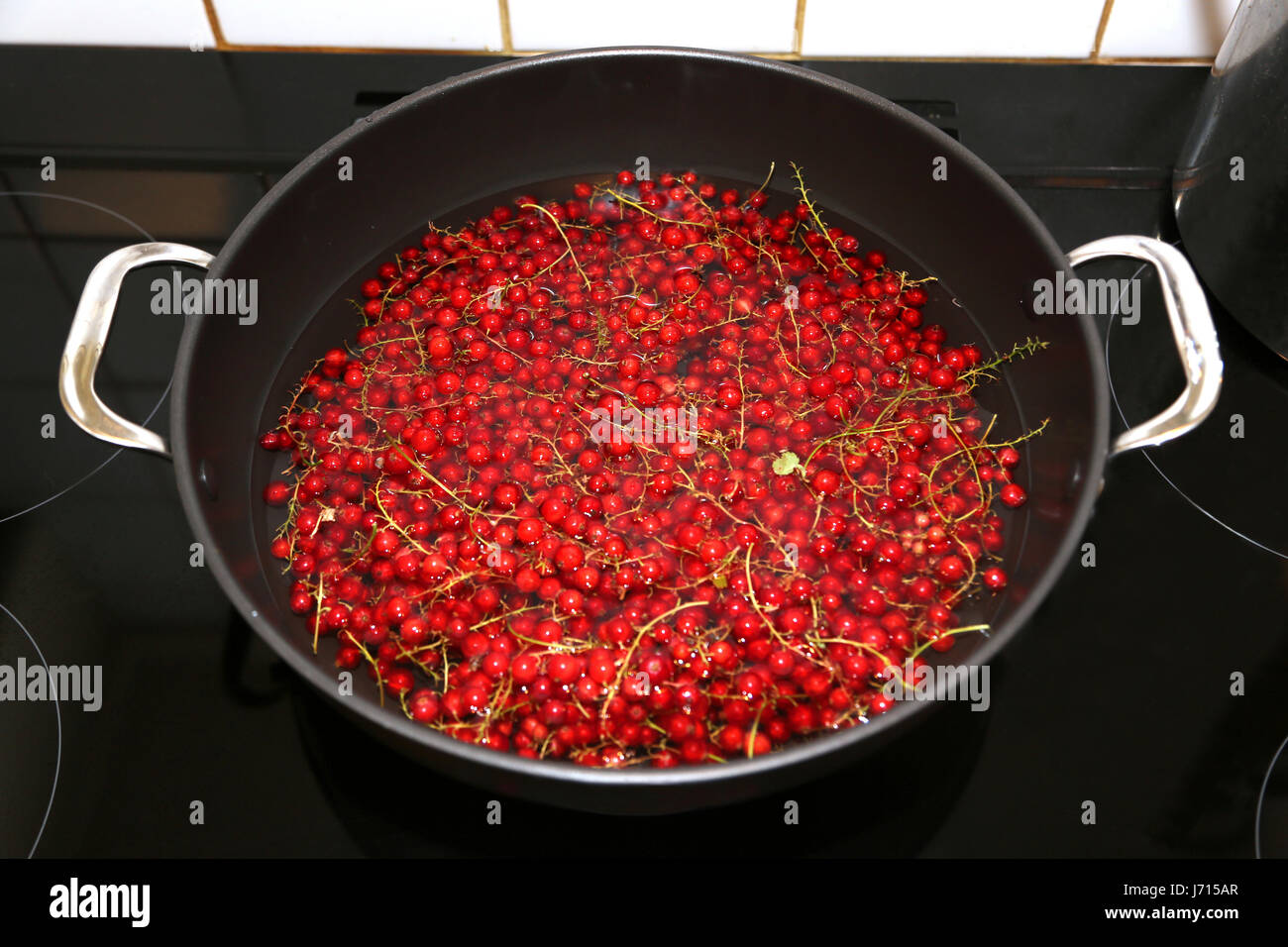 Redcurrants in wok on electric hob making jelly Stock Photo Alamy