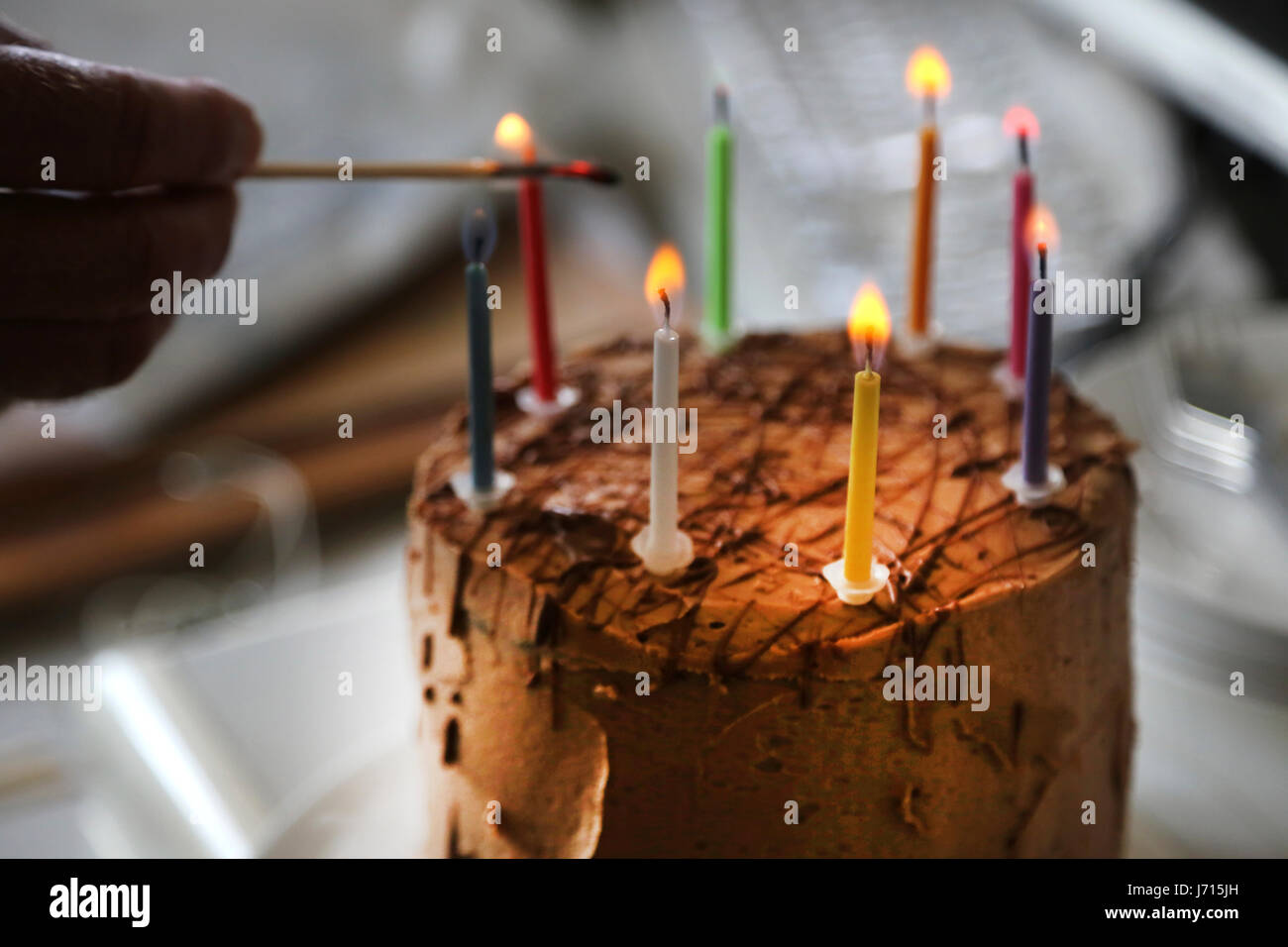 Lighting candles on chocolate birthday cake Stock Photo Alamy
