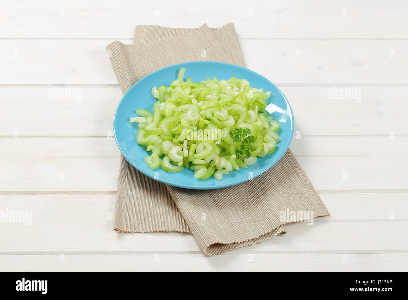 plate of chopped celery stems on beige place mat Stock Photo