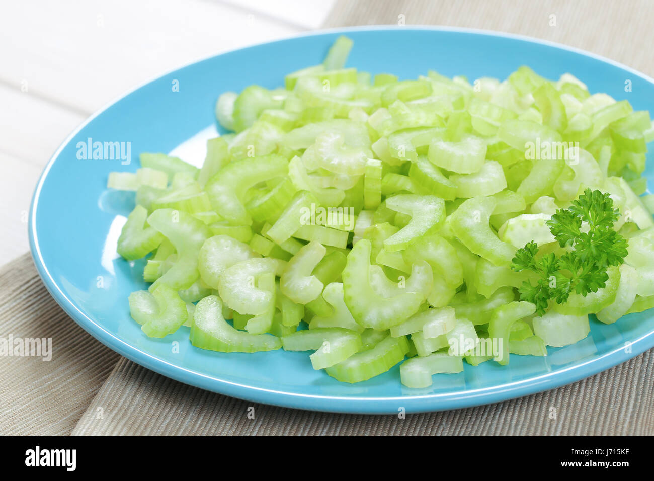 plate of chopped celery stems on beige place mat - close up Stock Photo