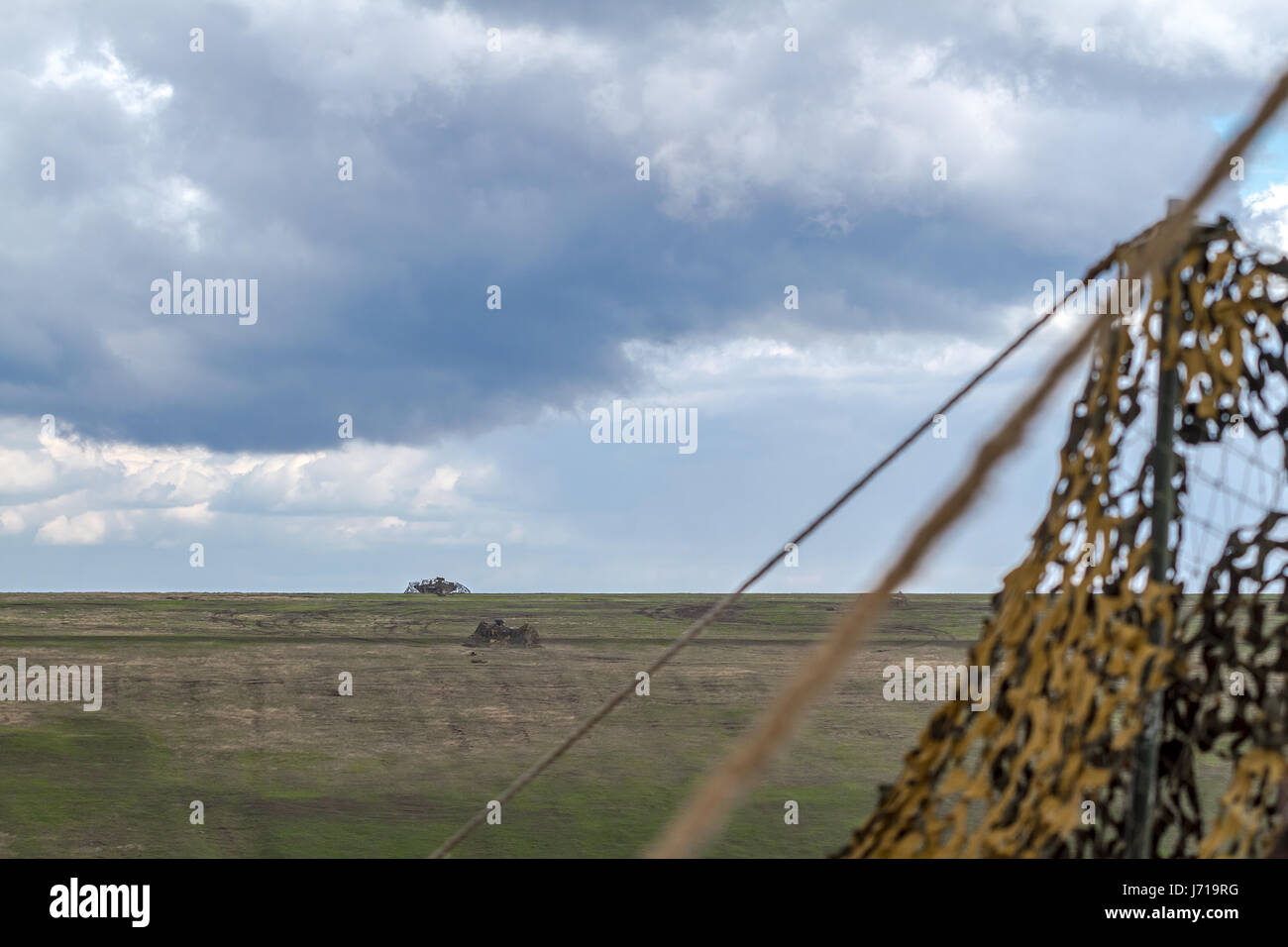 British soldiers run for a new position while being defended by a Romanian tanks and an attack helicopter during the NATO military drill 'Wind Spring -15' at Smardan shooting range Stock Photo