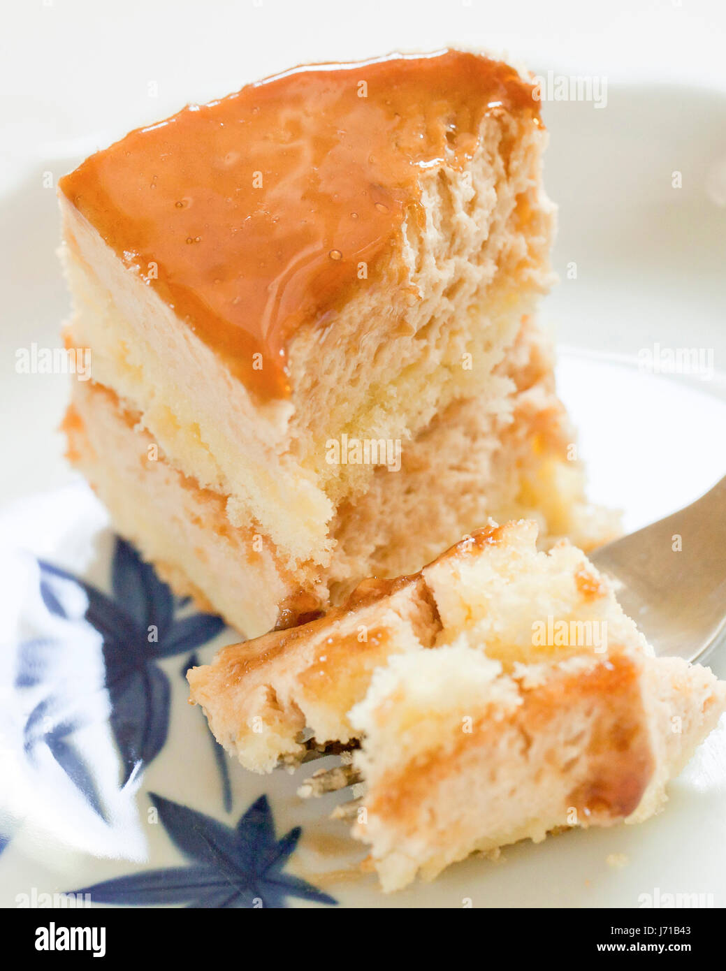 Half-eaten slice of layered cheesecake on dish - USA Stock Photo