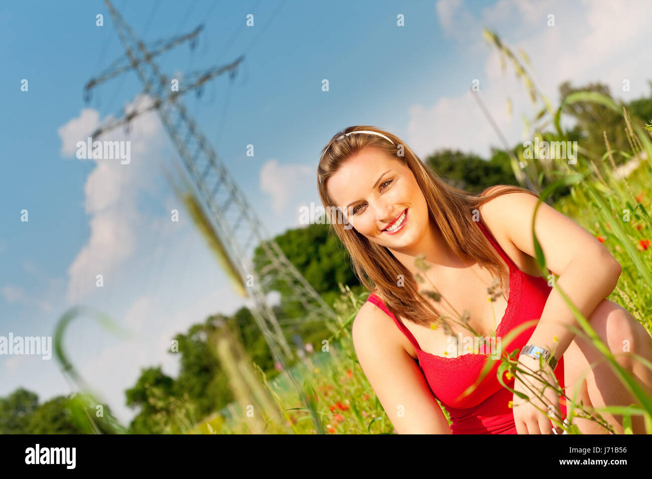 woman field crouch crouching put sitting sit meadow grain cereal woman blue Stock Photo