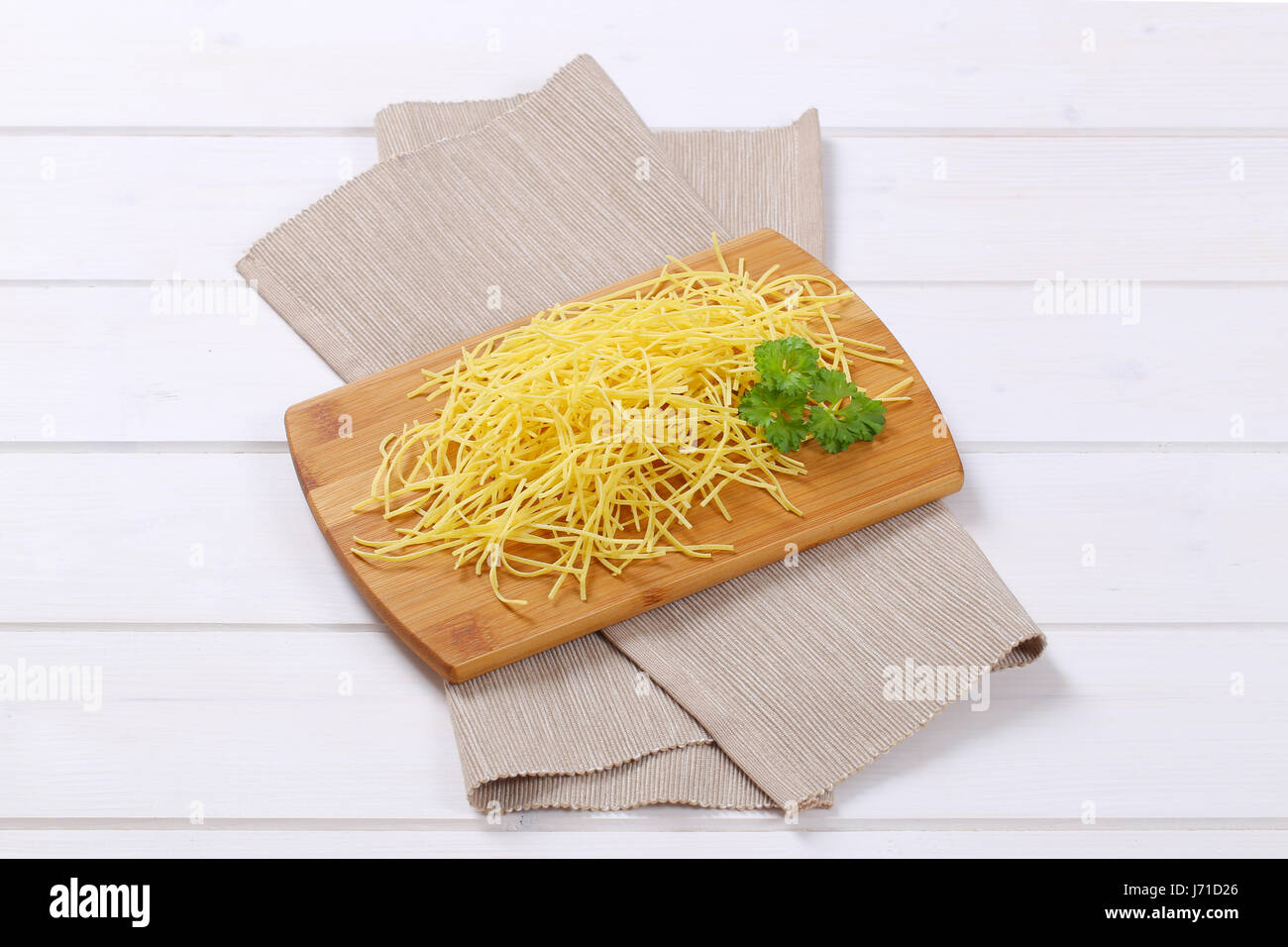 heap of dry soup noodles on wooden cutting board Stock Photo