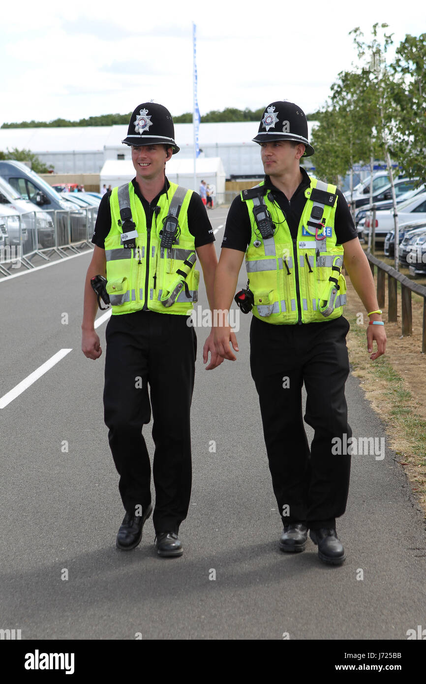 policeman british policemen police walk go going walking uniform helmet patrol Stock Photo