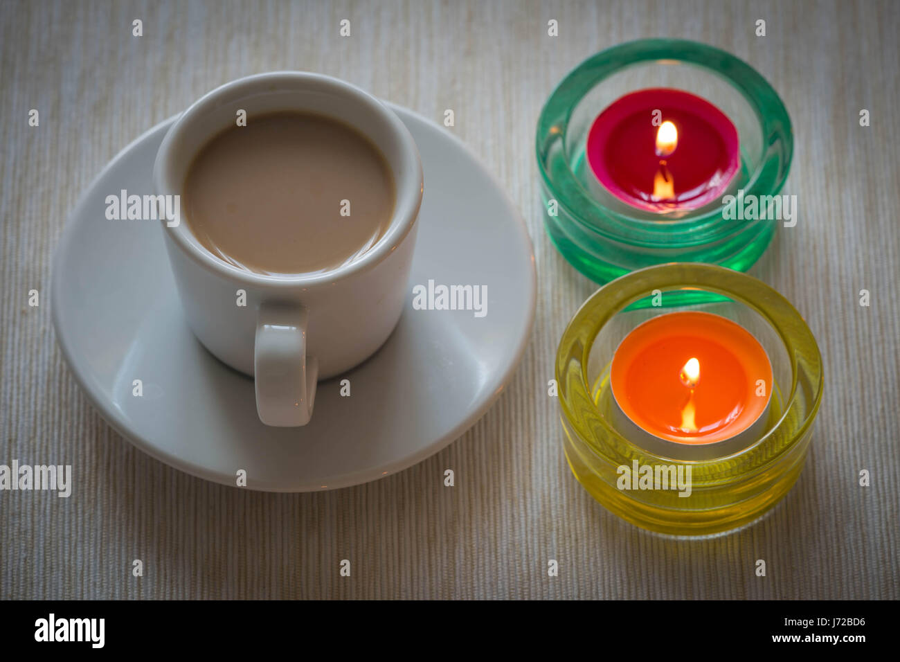 Homemade cup of coffee surrounded by candles / hygge time Stock Photo