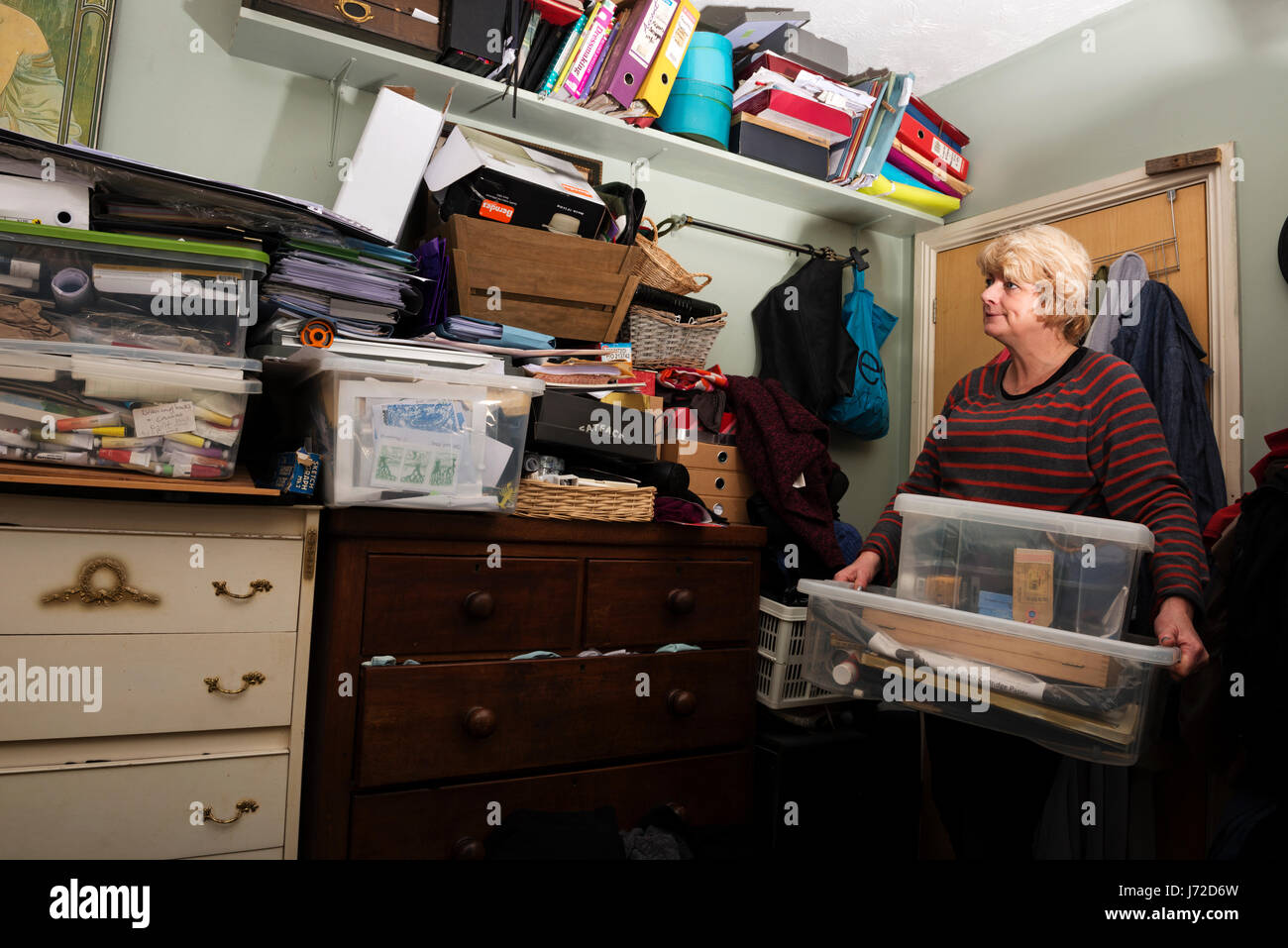 Woman with a cluttered bedroom Stock Photo