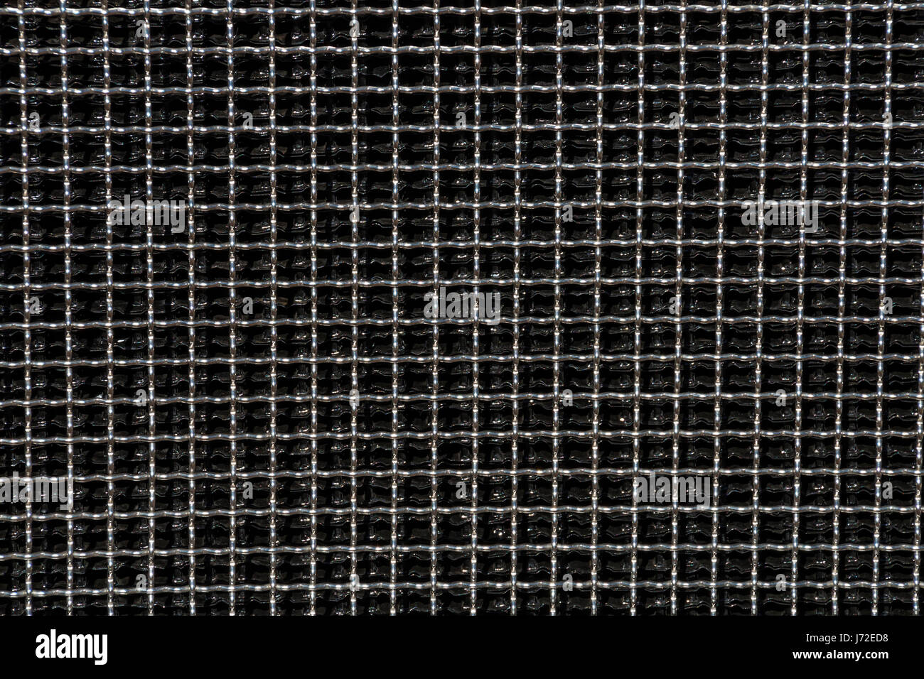 Close up of dark reflective  metal square grid patterns and textures background Stock Photo