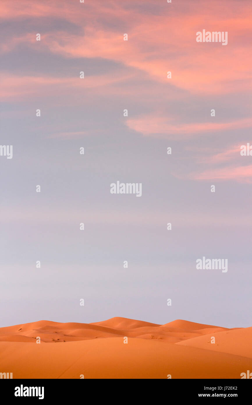 Red dunes and pink clouds at the desert near Merzouga, Morocco Stock Photo