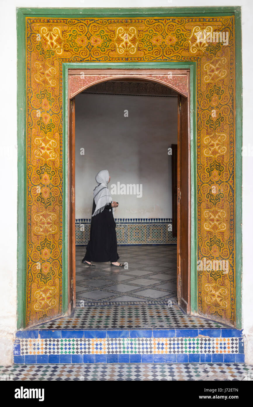 A woman walking across a doorway at the Bahia Palace, Marrakesh, Morocco Stock Photo