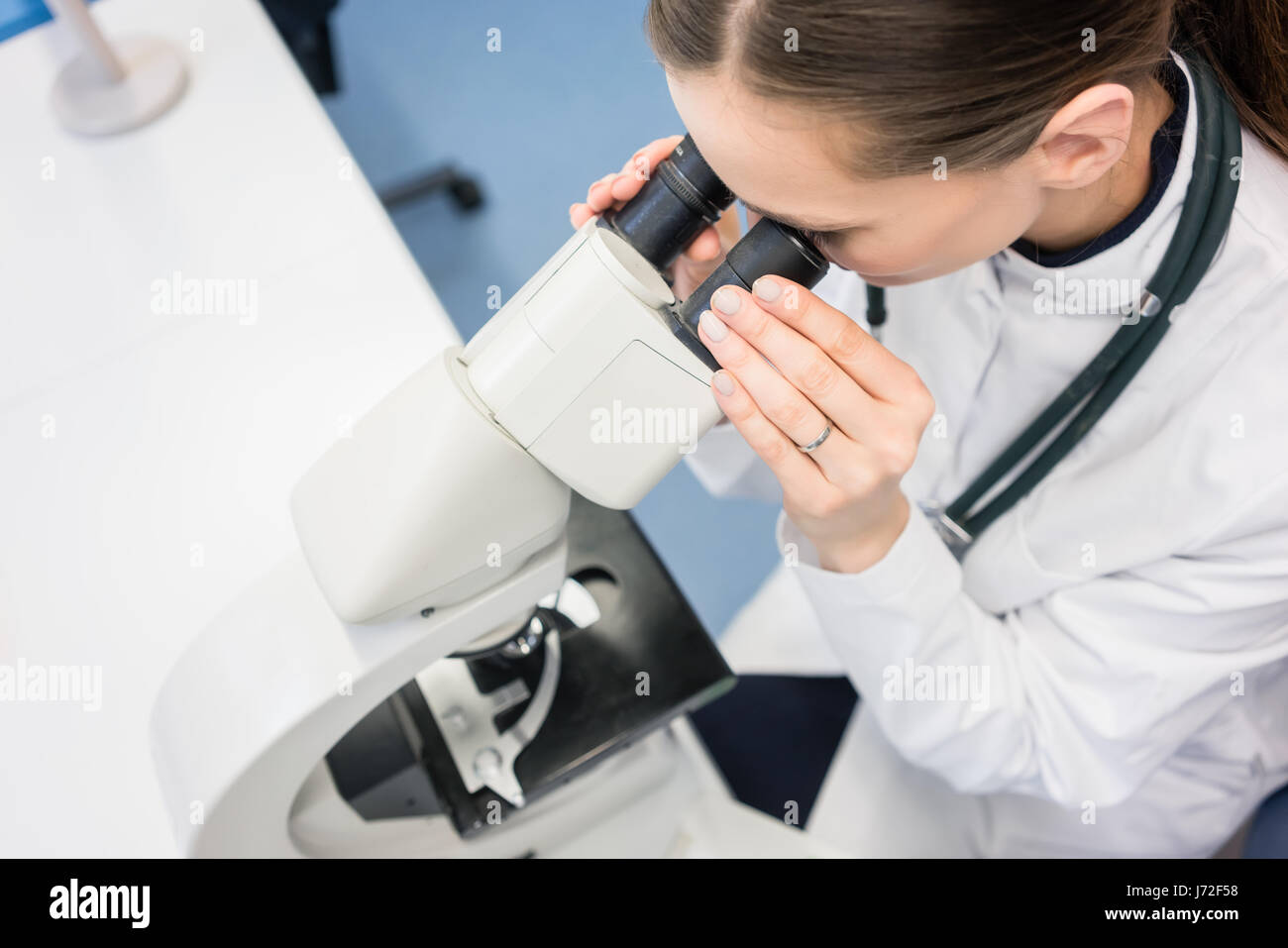 Doctor or biologist scrutinizing tissue under microscope Stock Photo