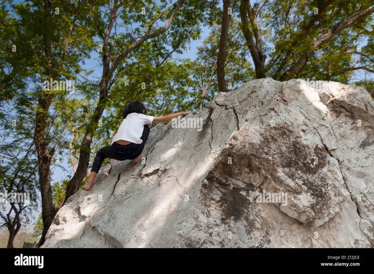 Young asian girl climbing rock boulder barehanded Stock Photo - Alamy