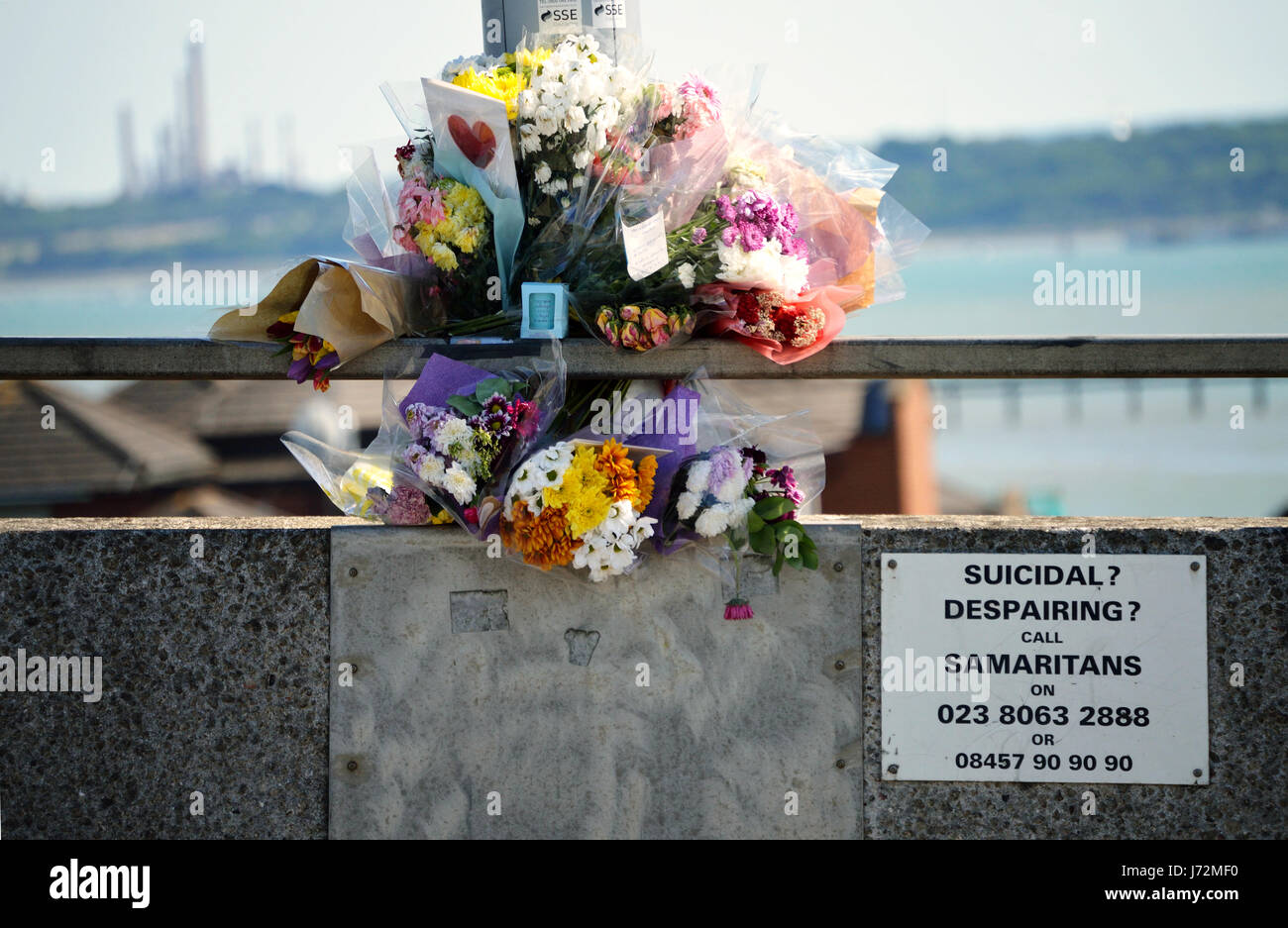 Floral tributes laid in memory of a suicide victim on Itchen bridge in Southampton, UK, with the Samaritans helpline number next to it Stock Photo