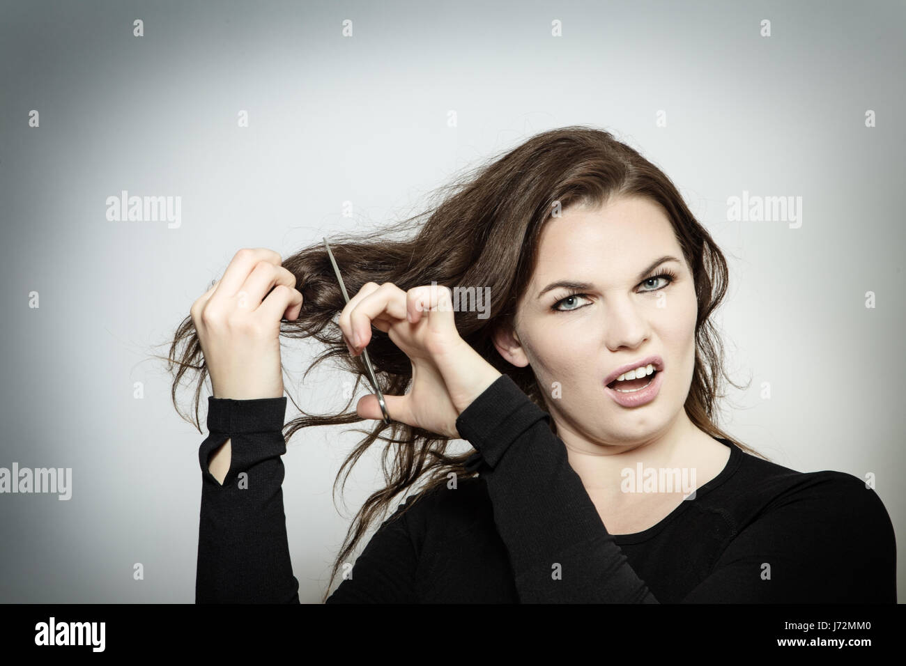 woman having a bad hair day about to cut her hair off Stock Photo