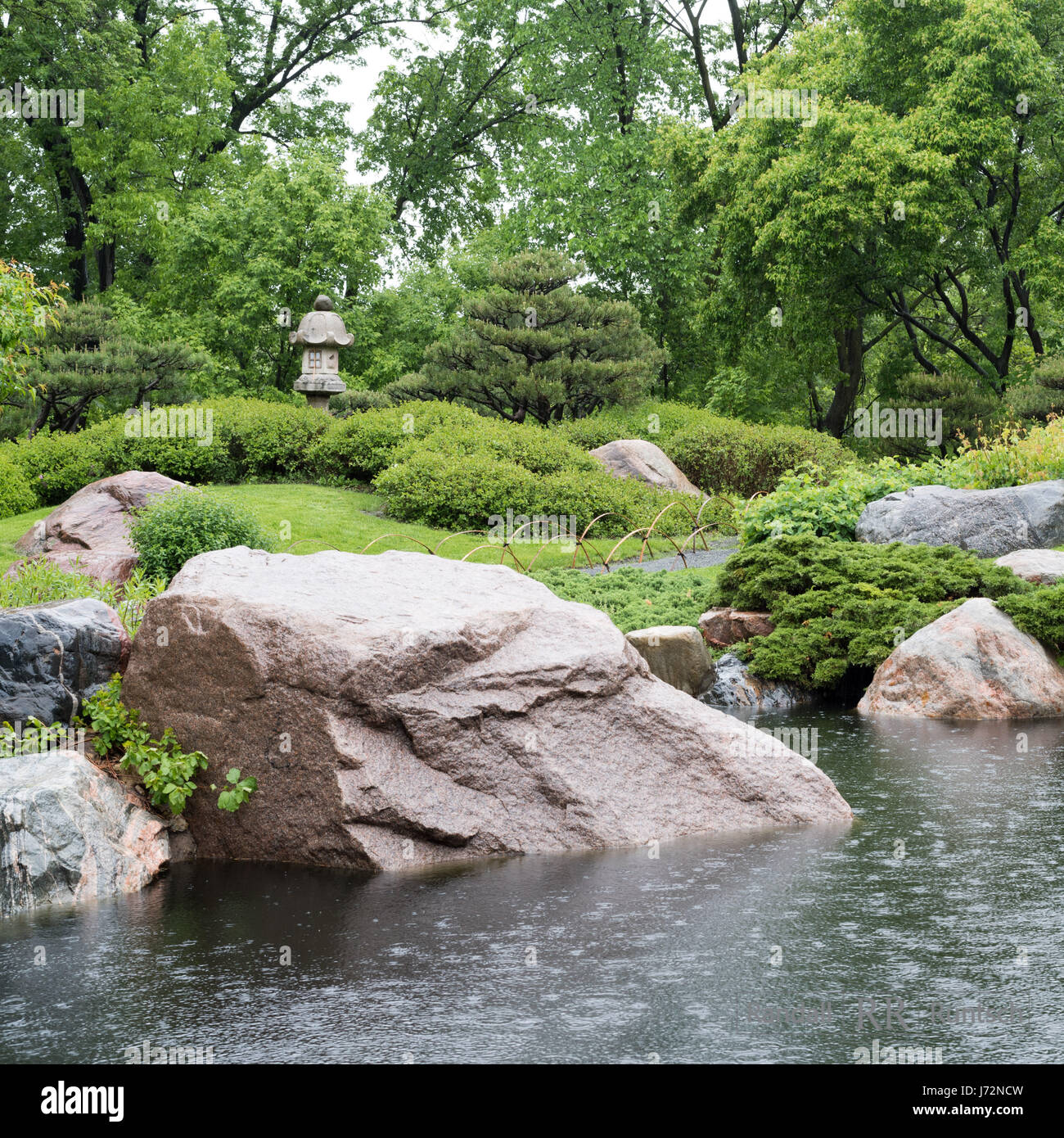 A stone lantern near a pond in a Japanese garden Stock Photo
