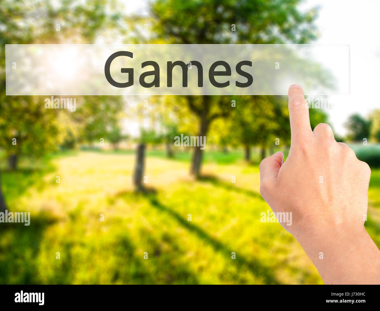 Games - Hand pressing a button on blurred background concept . Business, technology, internet concept. Stock Photo Stock Photo