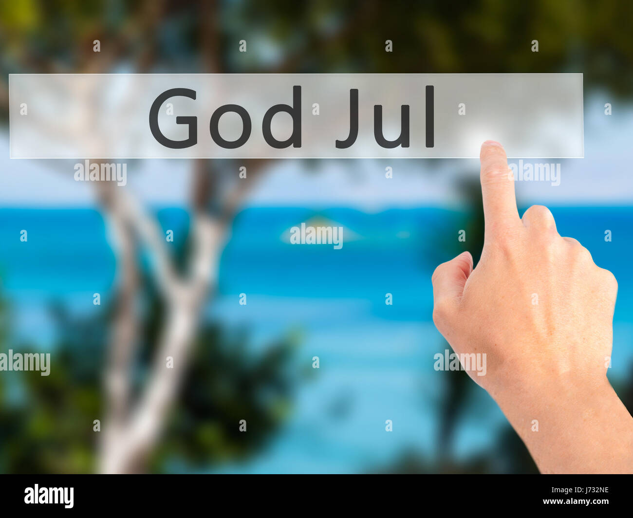 God Jul (Merry Christmas in Swedish) - Hand pressing a button on blurred background concept . Business, technology, internet concept. Stock Photo Stock Photo