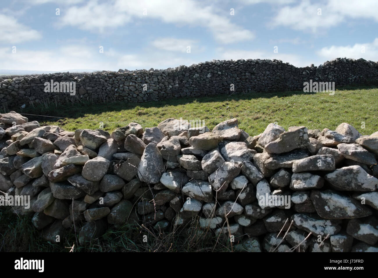 stone wall ireland irish ancient rocks stone field wall cloudy brick barrier Stock Photo