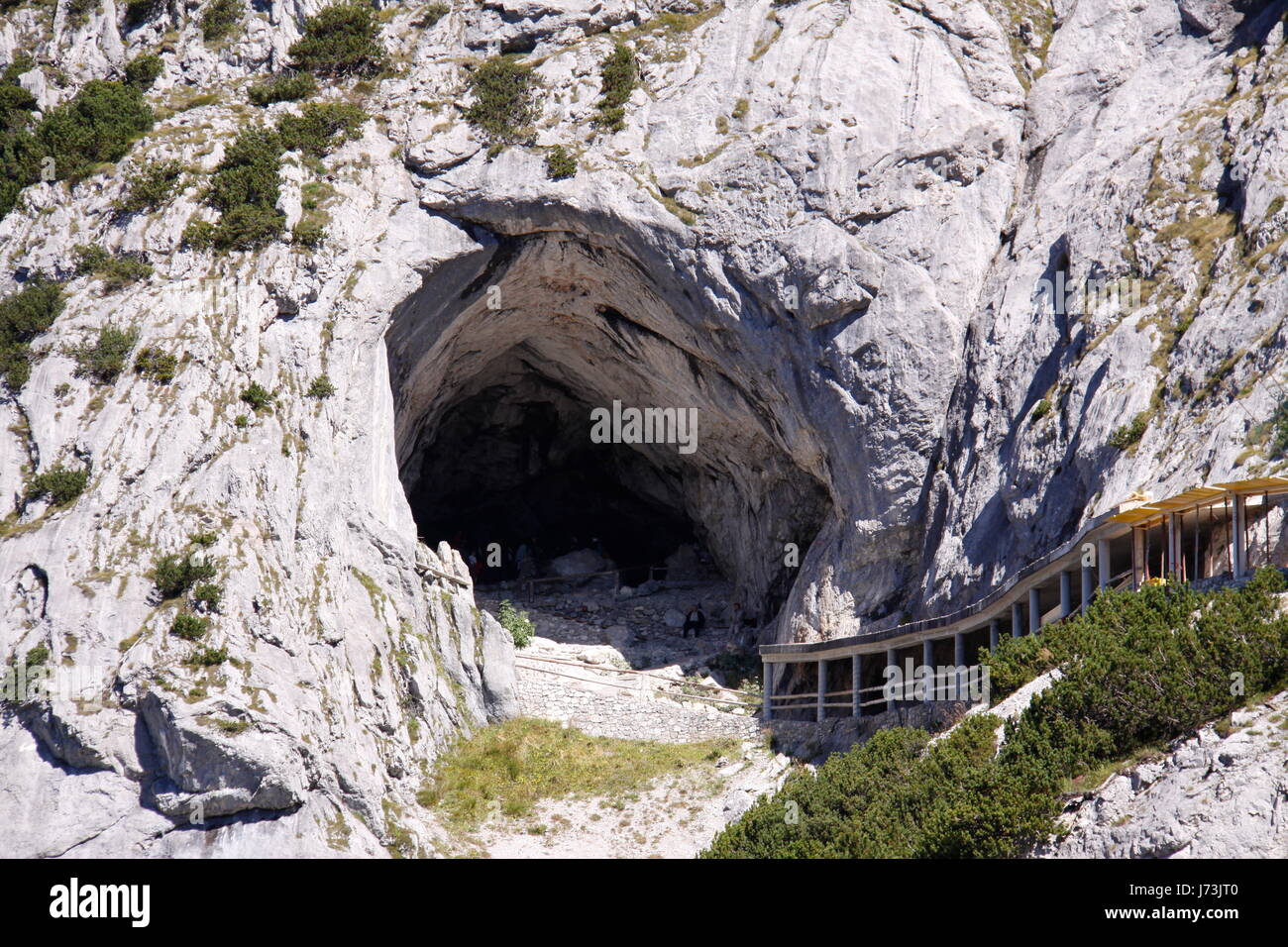cave alps entrance hole throw giant ice world mountain blue tree
