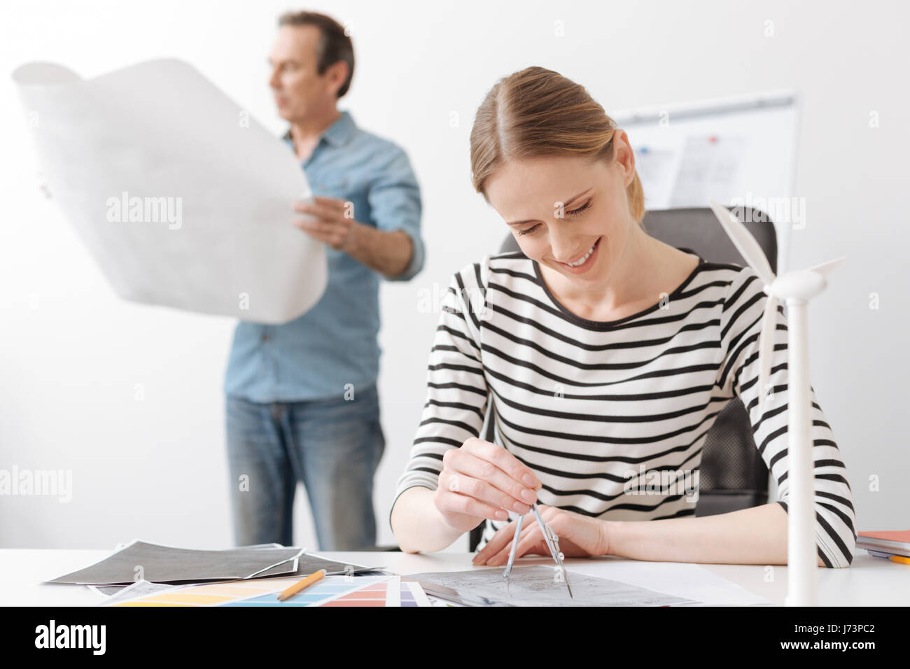 Positive professional woman engineer drawing with compasses Stock Photo ...
